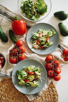 Top view of a vibrant vegetable salad featuring fresh ingredients on plates and a towel.
