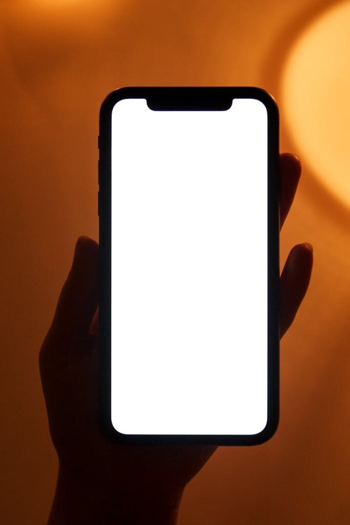 Smartphone with blank screen held by a hand, perfect for app or design mockups.